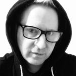 Headshot of Isaac Toast in a hoodie wearing eyeglasses.